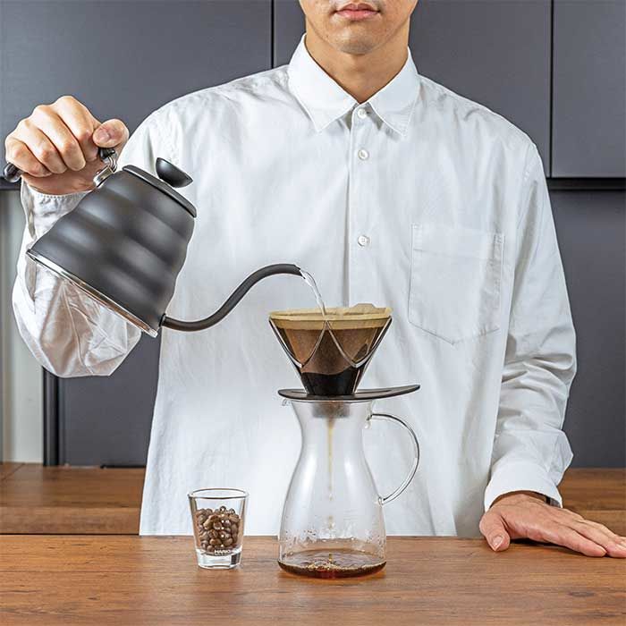 menuangkan air panas ke bubuk kopi pada hario v60 black